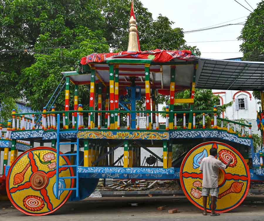 An artisan paints the wheel of the ISKCON chariot ahead of Rath Yatra on Tuesday.