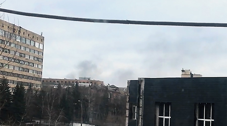 Smoke billows out at a distance, as seen from the window of the flat