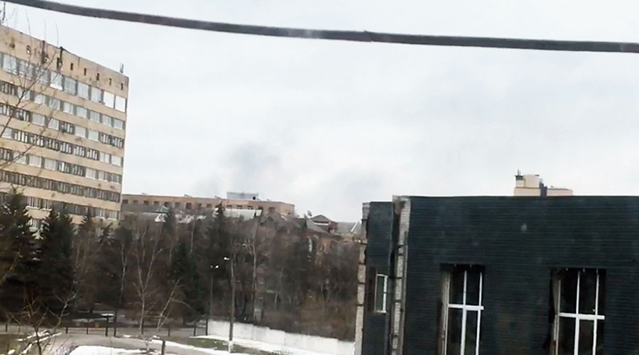 Smoke billows out at a distance, as seen from the window of the flat