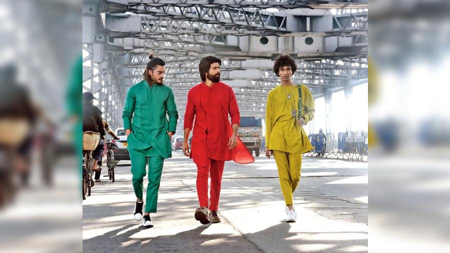 Shot against the backdrop of Howrah Bridge, (l-r) Kutubuddin Sheikh wore an emerald green linen asymmetric kurta with cropped trousers, Mohammed Iqbal donned a jacket kurta designed with asymmetric cuts paired with cropped trousers and Udit Pande sported a radiant lime green box-pleated kurta paired with box-pleated trousers, accessorised with kantha stitch handbag.