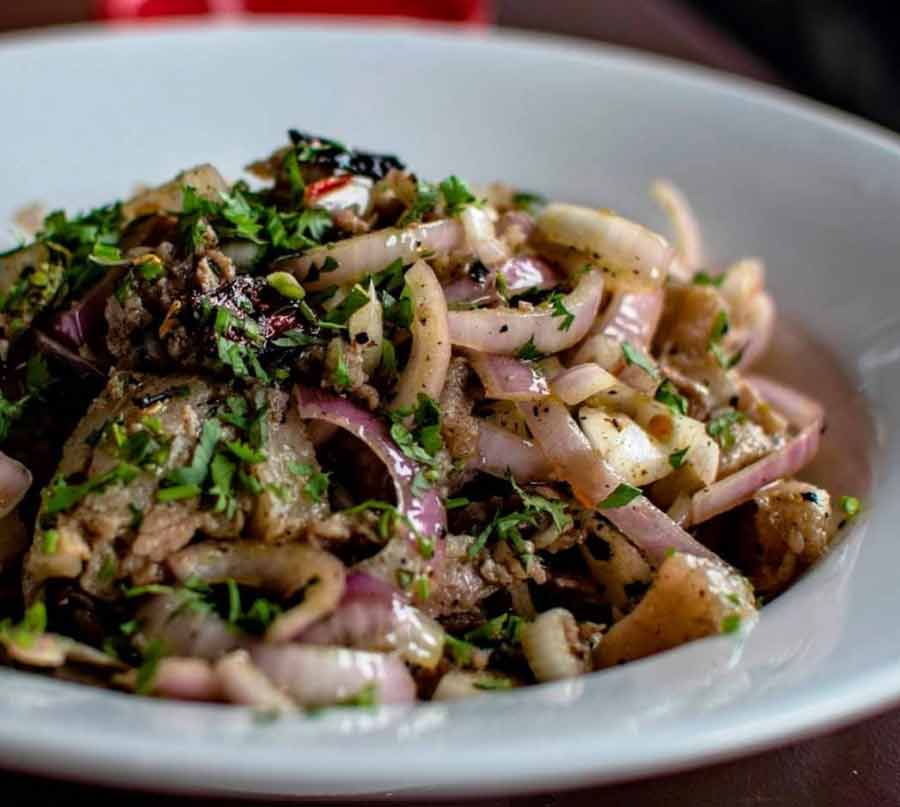 PORK BHORTA AT CAFE PORKOTINI: Indigenous to certain communities in Tripura, this bharta features the familiar medley of roasted chillies, ginger, onion and coriander. Seasoned with salt, pepper and lemon juice, this salad lets all the flavours sing. The final drizzle of mustard oil makes it a must-try!