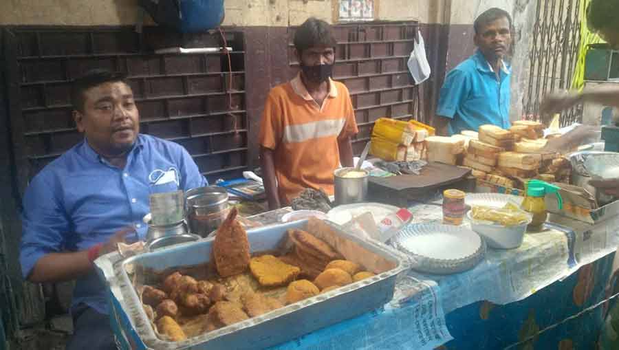 Bubai babu (L) and other employees of Chitto Babur Dokan await customers