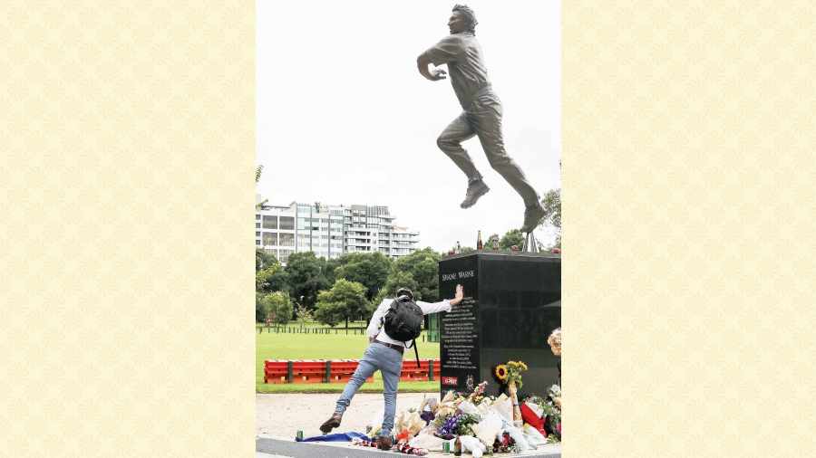 A fan pays respects at the statue of Shane Warne outside the Melbourne Cricket Ground on Saturday.