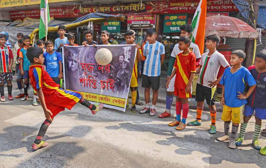 Kids play football near Shyambazar crossing at an anti-war demonstration on Sunday