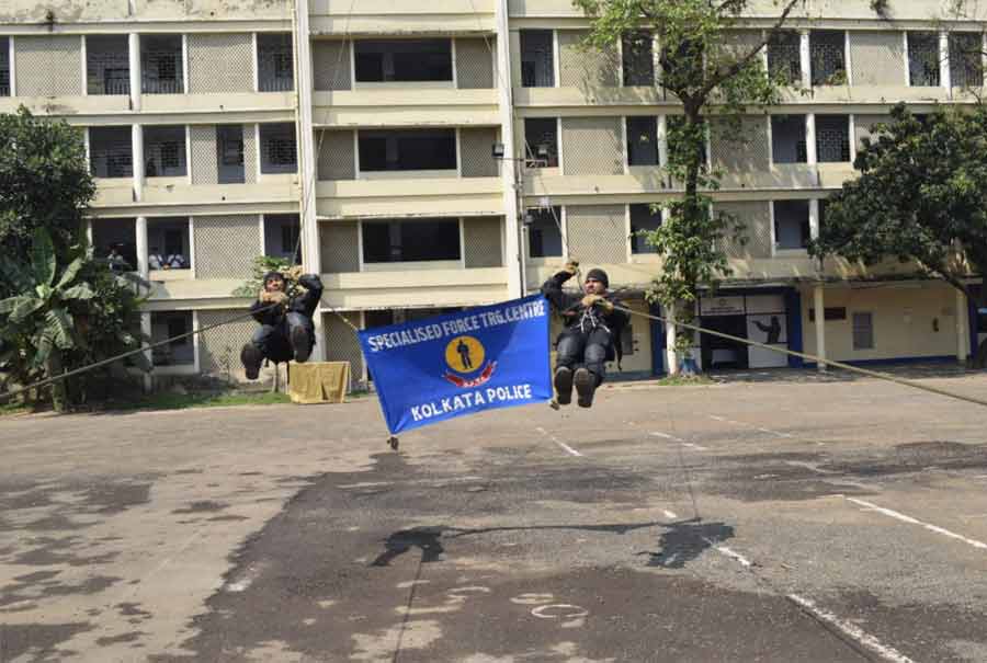 Two cops rappel down a building using ropes. Kolkata police commissioner Vineet Kumar Goyal attended the demonstration