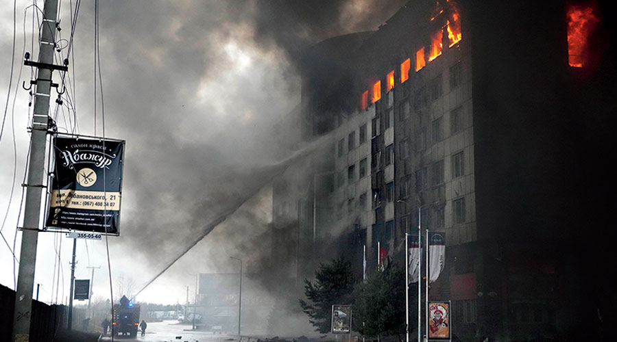 Firefighters hose down a burning building after bombing in Kyiv, Ukraine, Thursday, March 3, 2022. 