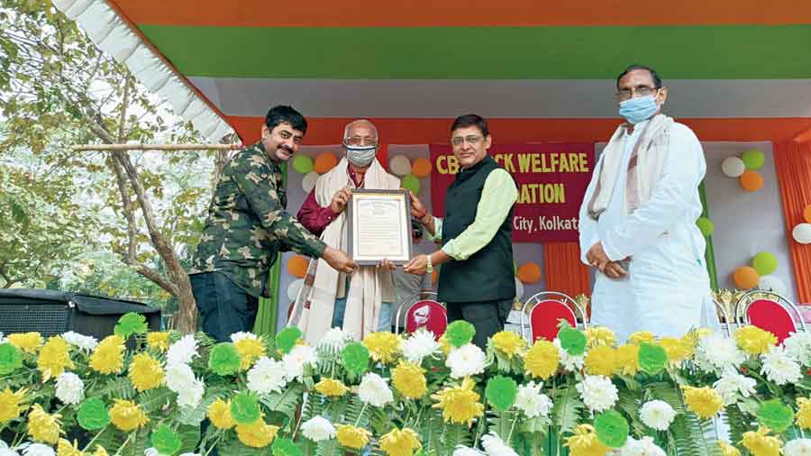 A senior citizen is felicitated on stage at CB Park
