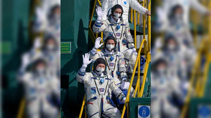 (L-R) Expedition 65 Russian cosmonaut Oleg Novitskiy, NASA astronaut Mark Vande Hei and Russian cosmonaut Pyotr Dubrov wave farewell prior to boarding the Soyuz MS-18 spacecraft for launch at the Baikonur Cosmodrome on April 9, 2021 in Kazakhstan. 