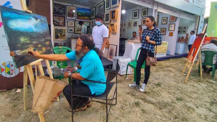 An artist busy at work with his brush  at the Charukala Festival on the Rabindra Sadan campus on Sunday. 