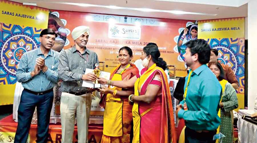 Joint secretary  rural development ministry Charanjit Singh hands over certificate and trophy to Jharkhand women entrepreneurs in Noida on Sunday. 