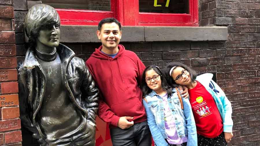 Subhajit, his daughter and his niece pose with a John Lennon statue in Liverpool