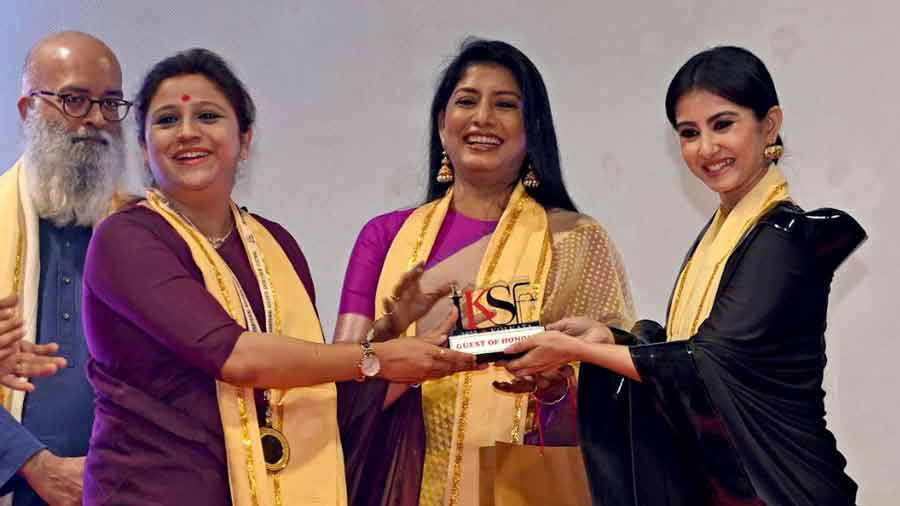 Monami Ghosh (right) presents Indira Dhar Mukherjee (left) with the award as Jaya Seal Ghosh applauds 
