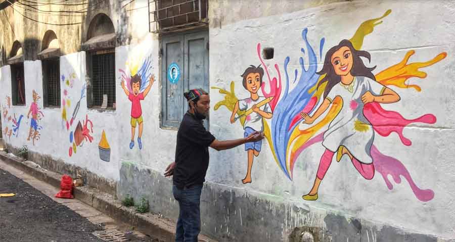 An artist paints a mural in north Kolkata to mark the festival of colours on Thursday, the eve of Doljatra this year