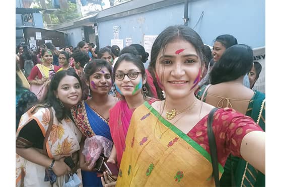 Students take groupfie with aabir smeared on their faces. 
