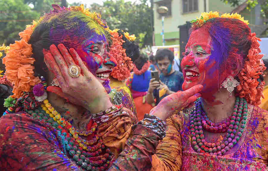 Women covered in bright colours smear ‘aabir’ on each others’ faces in the city  on Friday