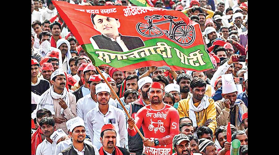 A supporter holding the party flag attends an election campaign rally of Samajwadi Party President Akhilesh Yadav for the ongoing UP Assembly elections, in Balrampur. 