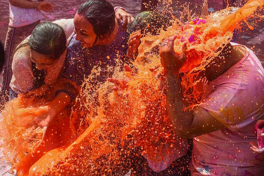 People spray coloured water on each other, in celebration of the festival of Holi, in Chennai.