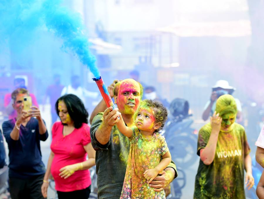 People play with dry colours during Holi festival in Mumbai,.