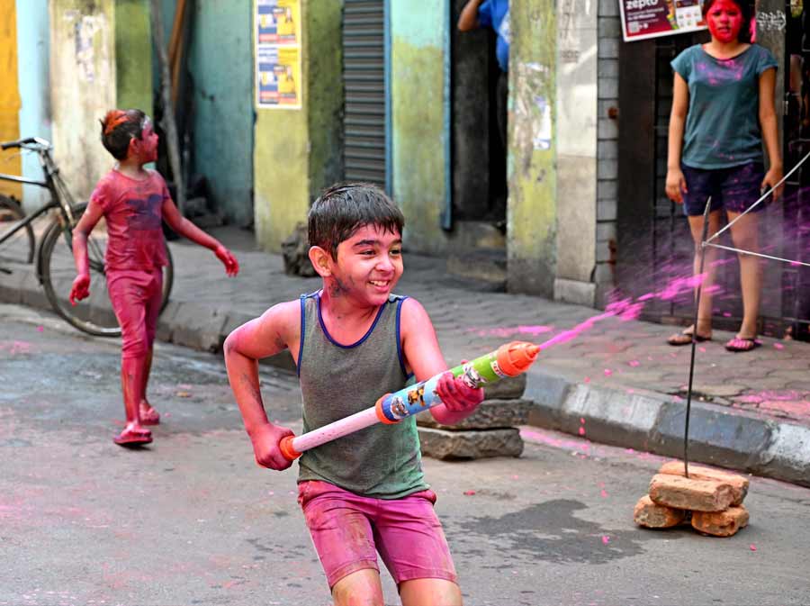 COLOURS OF INNOCENCE: A kid uses a 'pichkari' or water gun to spray coloured water in south Kolkata on Friday, March 18