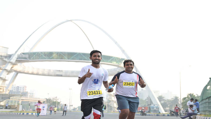 Participants in the marathon race run past the Biswa Bangla Gate on Sunday 