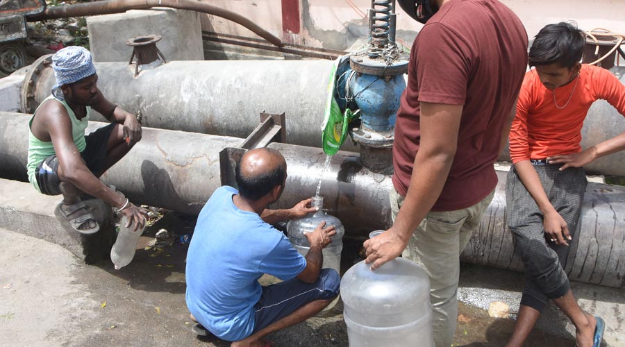 Residents of Dhanbad collecting water from a leakage water supply pipe in Dhanbad on Monday.