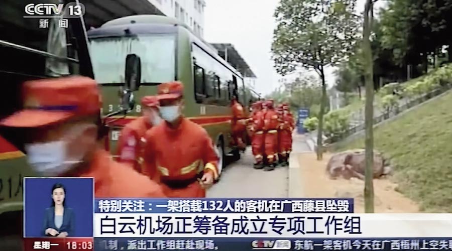 A picture taken from TV footage shows emergency workers preparing to travel to the site of the plane crash near Wuzhou, China, on Monday. 