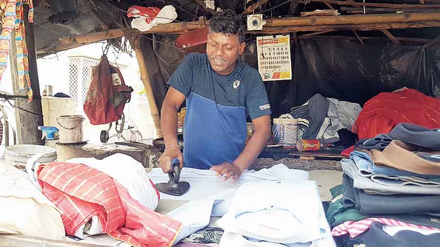 Santosh Kumar irons a shirt at his stall in BE Block. (Brinda Sarkar)