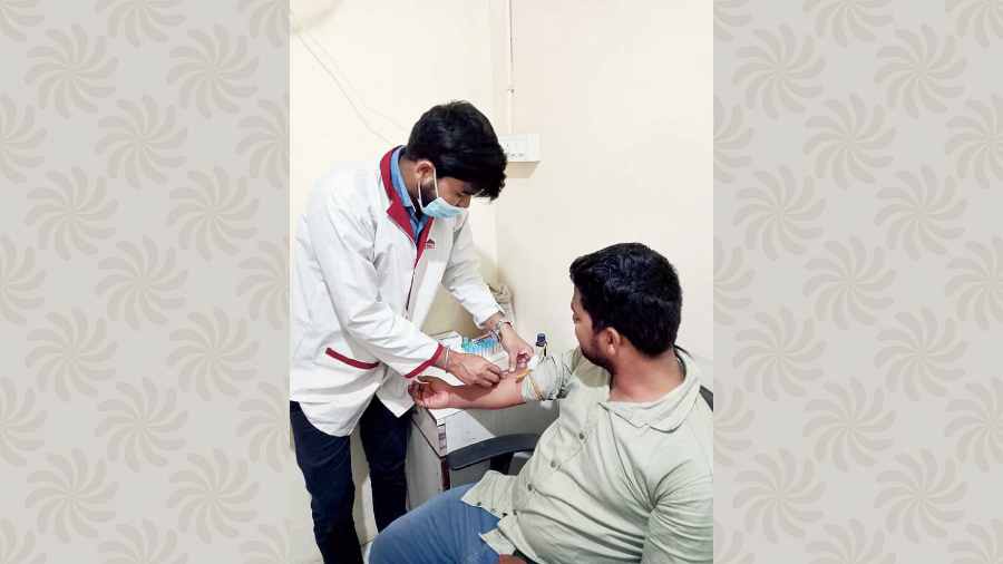 Sukdeb Das Mahanta collects a blood sample at the laboratory