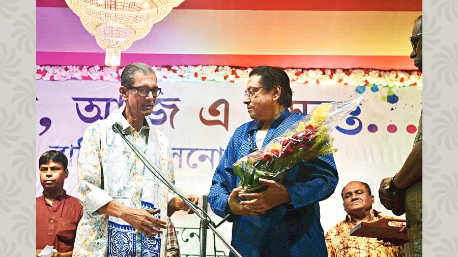 Sivaji Chatterjee offers a bouquet of flowers to veteran guitarist Swapan Sen