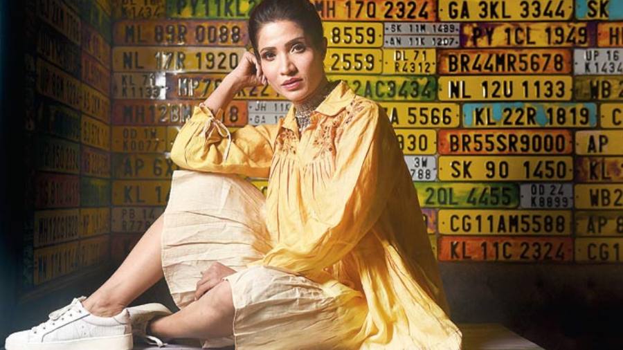 Bright and easy-breezy, Richa’s poplin flowy dress from Sixth Avenue in an ombre tone of yellow and white stands out against the number-plate decor wall of Cheap Charlie. The white sneakers, hair tied up into a bun and silver neckpiece complete the summer casual daywear look.