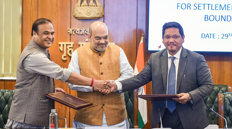 Assam Chief Minister Himanta Biswa Sarma(L) shakes hands with Meghalaya Chief Minister Conrad K Sangma after signing an agreement to resolve the 50-year-old pending boundary dispute between their states, in the presence of Union Home Minister Amit Shah, at North Block in New Delhi, Tuesday, March 29, 2022. 