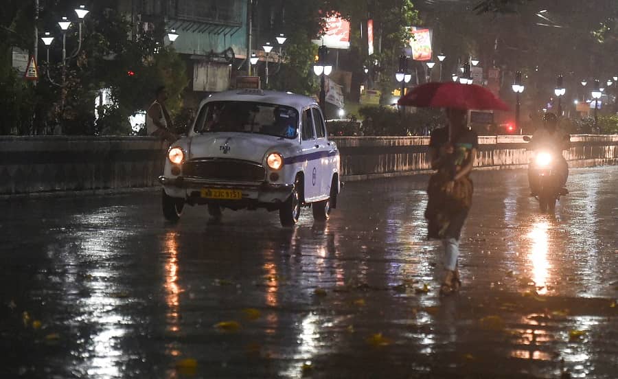 Vehicles move slowly on the street during sudden rain in Calcutta on Saturday 