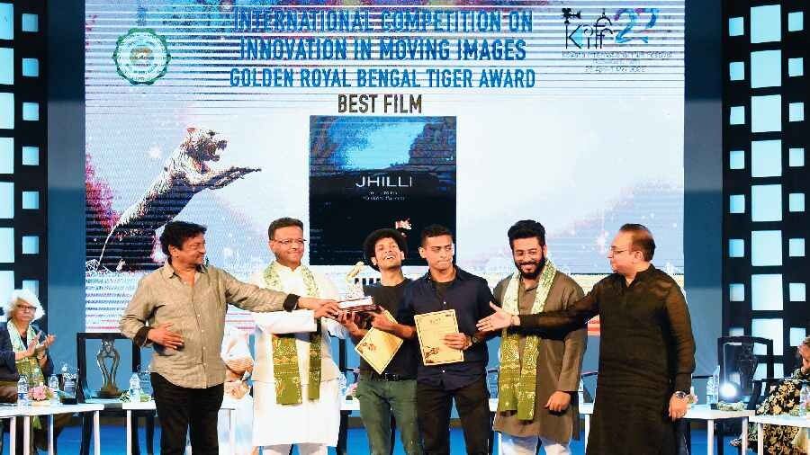 Director Ishaan Ghose and producer Goutam Ghose accept the Golden Royal Bengal Tiger Award for Best Film in the International Competition category for Jhilli on the concluding day of the 27th Kolkata International Film Festival at Rabindra Sadan on Sunday.