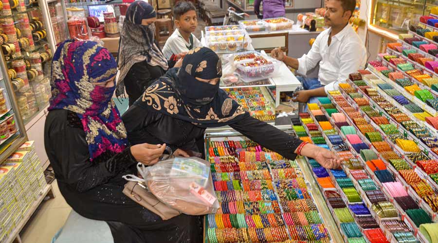 Muslim woman purchase bangles from a shop, ahead of the Eid-ul-Fitr festival, in Mirzapur