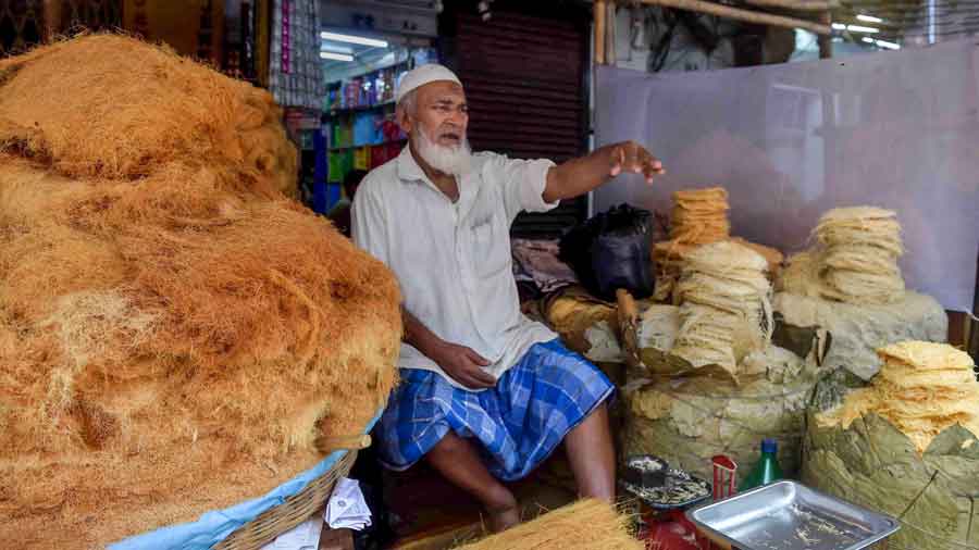 A Muslim vendor sells sweets ahead of the upcoming festival of Eid-ul-Fitr, in front of Nakhoda Masjid, in Kolkata