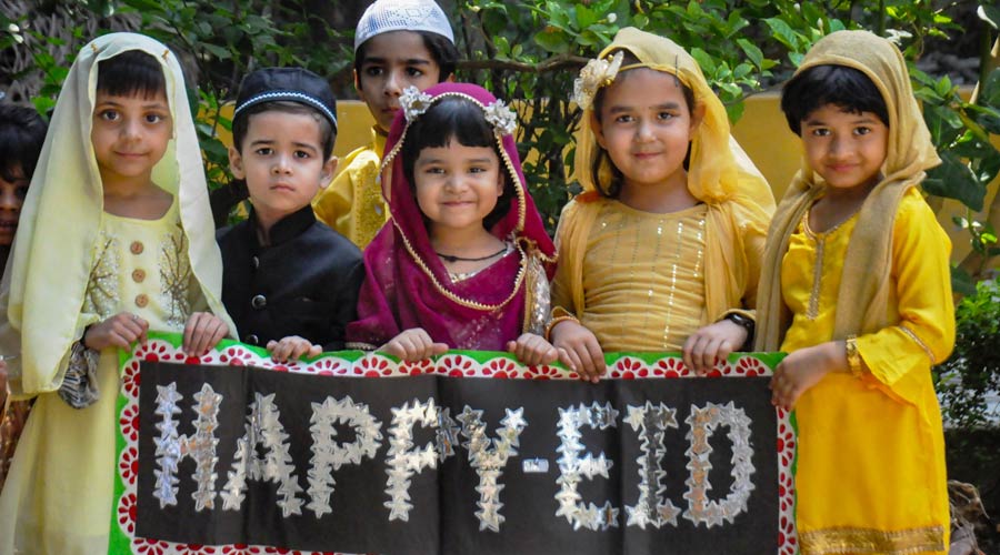 Young Muslim devotees wish Happy Eid, on the eve of Eid al-Fitr, in Moradabad