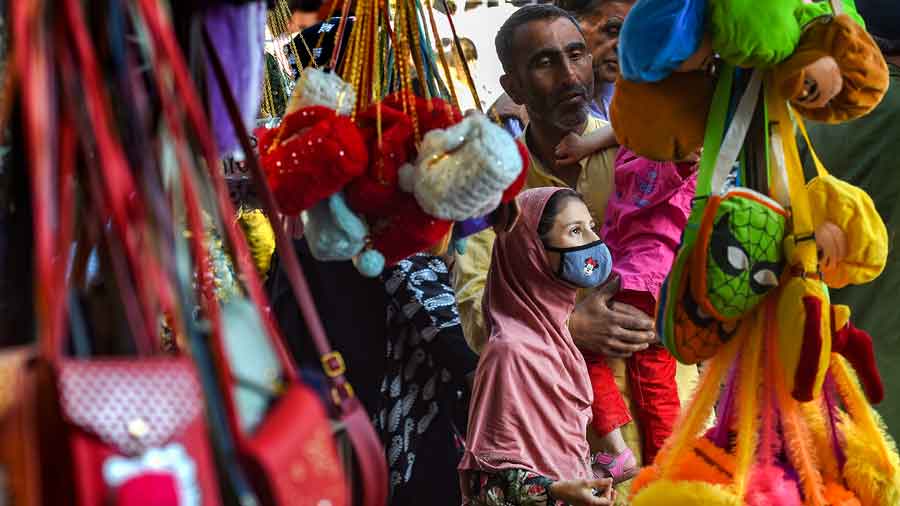 A girl with her father looks for a bag at a market on the eve of Eid-ul-Fitr, which marks the end of the holy month of Ramadan, in Srinagar