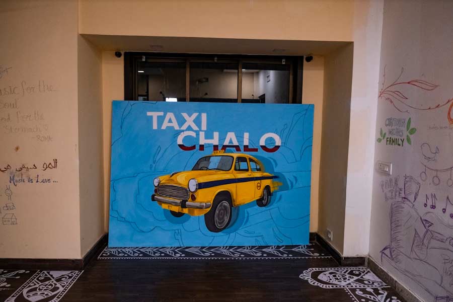 The room adjoining the terrace is adorned by arts of all kinds. From the floor bordered with alpana to a vibrant canvas of the iconic Kolkata taxi to the walls adorned with scribbled messages from visitors, it is a reminder of the artistic spirit that forms the core of Chaitown Community and all its endeavours