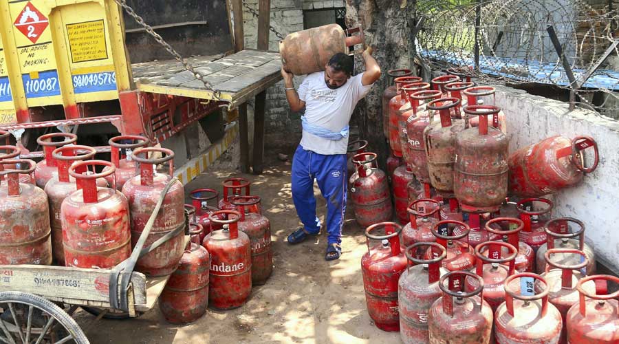 A man unloads LPG cylinders, as prices soar in New Delhi on Saturday.