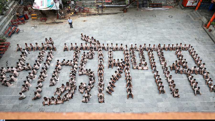 Children form a human chain as they celebrate Mother's Day, in Jammu