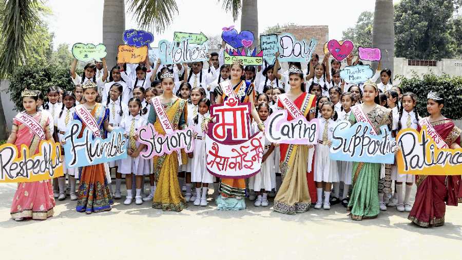 School students show their greeting cards made for their mothers during a programme organised on the eve of Mother's Day, at a school in Mirzapur