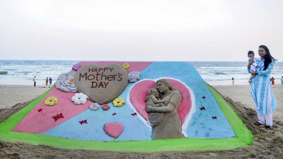 Sand artist Manas Sahoo creates a sculpture on the eve of International Mother's Day, in Puri