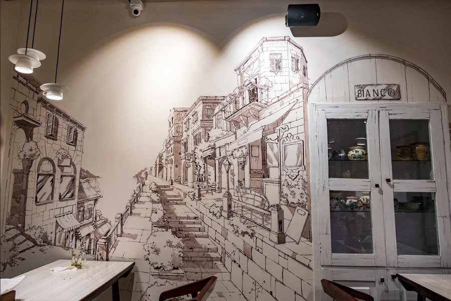 The walls of the cafe sport hand-painted illustrations of the streets in Milan — all painted by a talented team of artists from Kolkata. The illustrations on the wall of the second floor are of Pariyar’s favourite streets in Milan