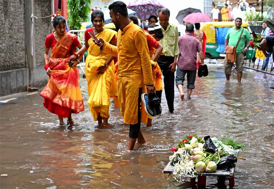 People dressed in vivid colours brave a waterlogged street to reach Jorasanko Thakurbari on the occasion of Rabindra Jayanti on Monday
