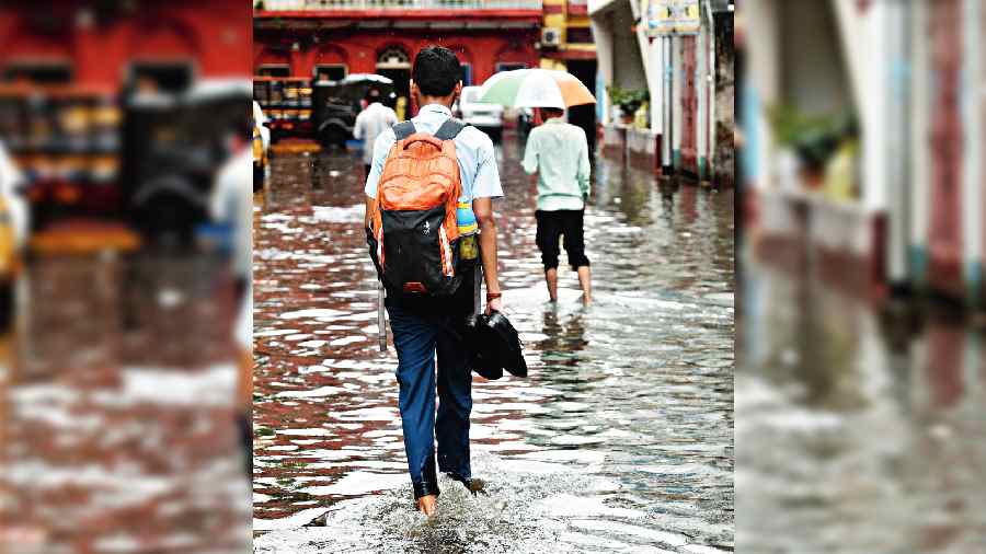 Pedestrians wade through ankle-deep water in north Kolkata around noon on Monday. 