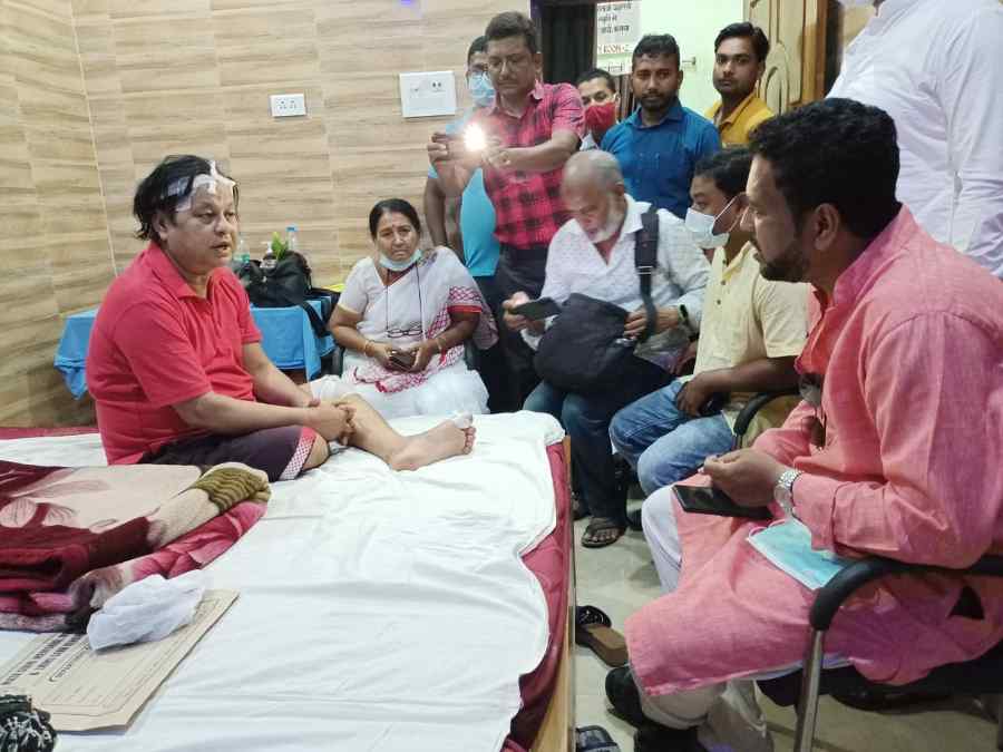 An injured Asim Sarkar interacts with acquaintances. 