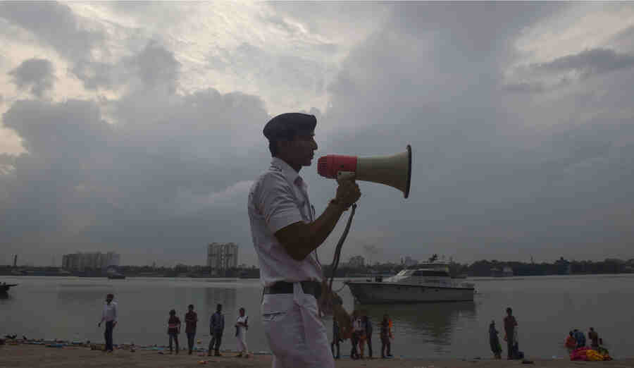 A river traffic cop makes an announcement as part of precautionary measures against Cyclone Asani, on the banks of Hooghly on Tuesday