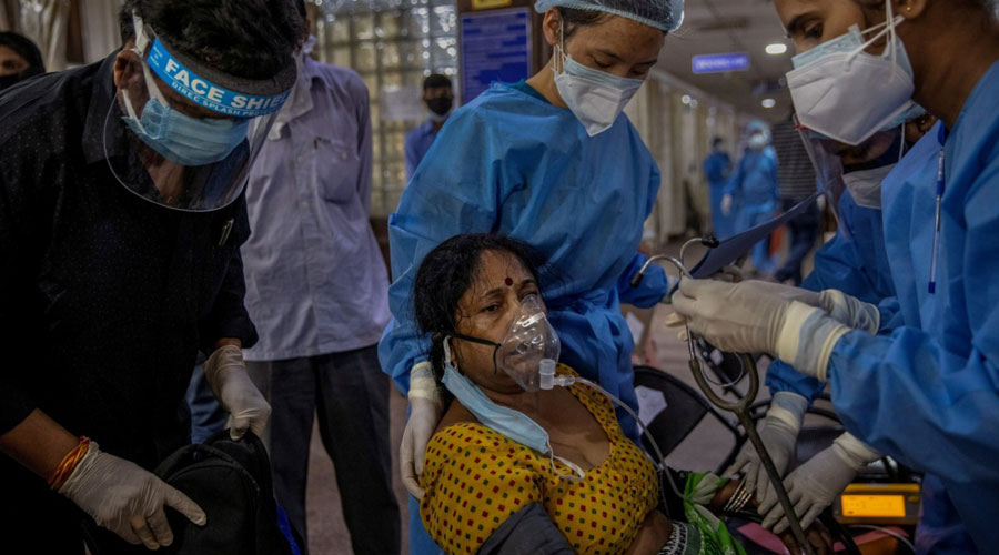 A female patient suffering from the coronavirus disease is attended to by hospital staff inside the emergency ward of the Holy Family hospital in New Delhi, India, April 29, 2021. (Danish Siddiqui)