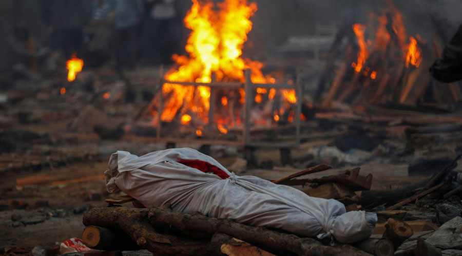 The body of a person, who died from the coronavirus disease, lies on a funeral pyre during a mass cremation at a crematorium in New Delhi, India May 1, 2021. (Adnan Abidi)