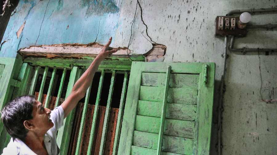 A resident shows a crack on a house in Durga Pituri Lane of Bowbazar.